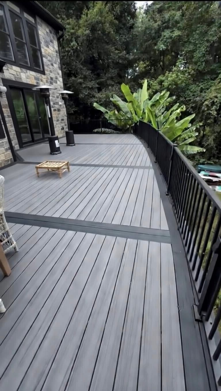 Custom curved composite deck with black aluminum railing by Vivid Outdoor Living