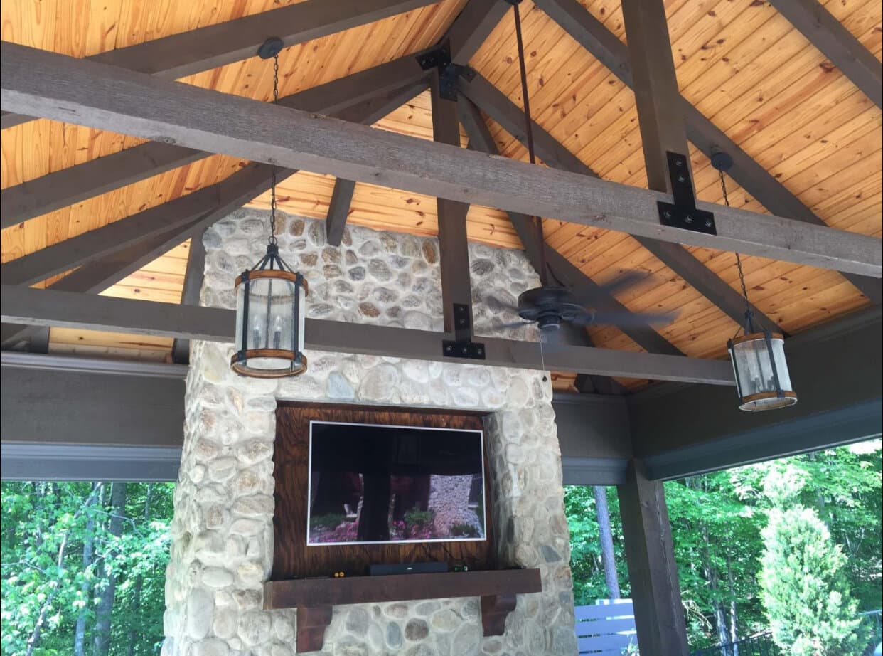 Outdoor kitchen with stone counter and built-in grill by Vivid Outdoor Living